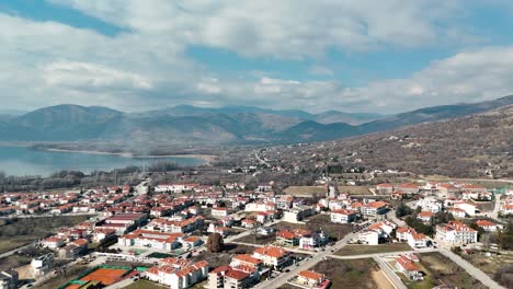 a drone shot of village mountain, warm weather, flying above a dreamy reflecting water lake, 4k video, european spring nature, beautiful landscape, scenic clouds