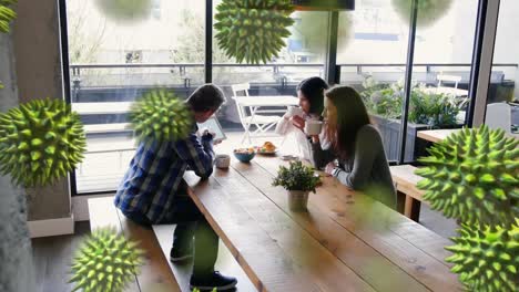 animation of macro coronavirus covid-19 cells spreading over caucasian people taking a breakfast