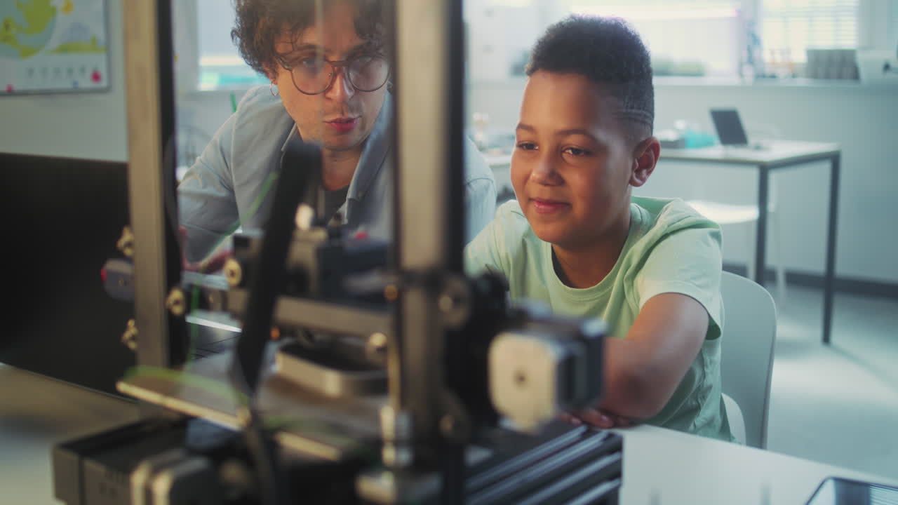 Teacher and student working on 3D printing project in a classroom.