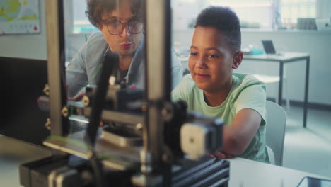 teacher and student working on 3d printing project in a classroom.