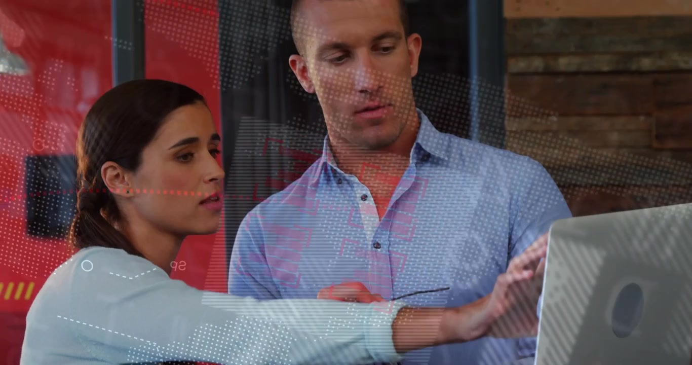 Pointing woman swiping laptop screen guiding man in blue shirt holding glasses at office, reviewing