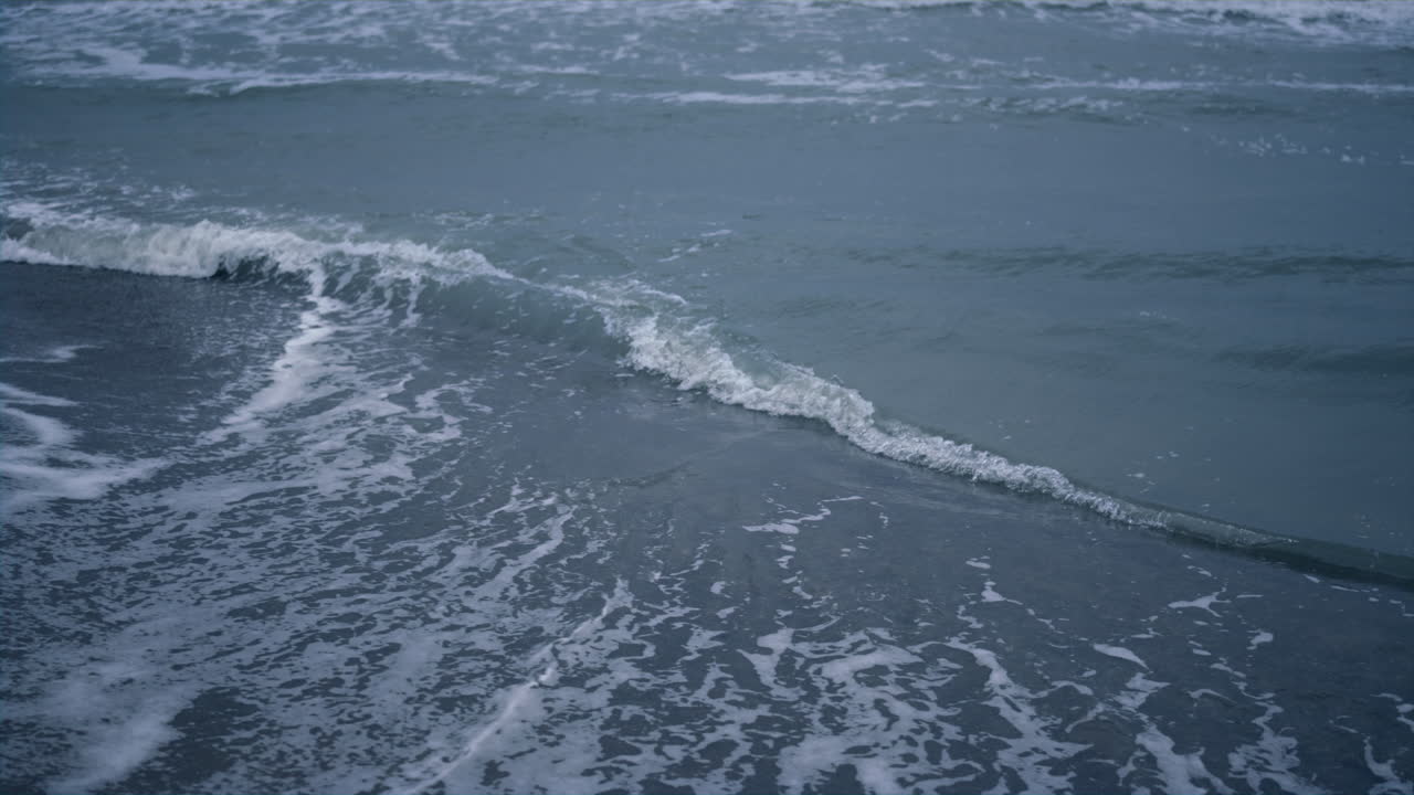 푸른 물 파도가 해안 배경을 충돌합니다. 바다 풍경에 바다 거품이 튀었습니다.