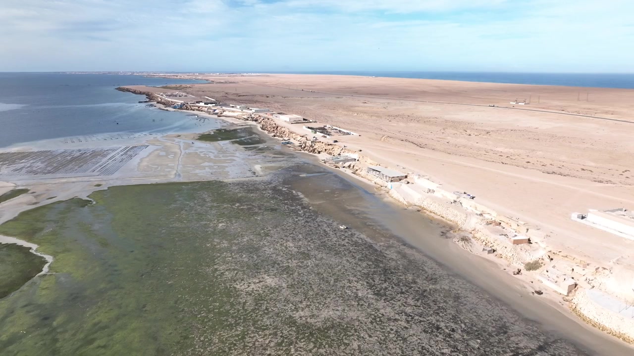Drohnen-Luftaufnahme eines Strandresorts mit Blick auf die Dakhla-Lagune, die die einzigartige Mischung aus Luxustourismus, Gezeitenlandschaften und der Atlantikküste der Sahara in Südmorokko zeigt.