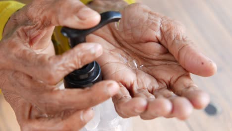 persona de edad avanzada que aplica desinfectante para las manos