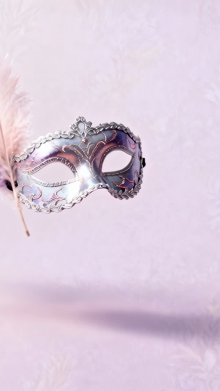 Video verticale: Maschera scorrevole che entra da sinistra, si centra su una parete rosa mostrando una piuma decorativa, con spazio per il testo.