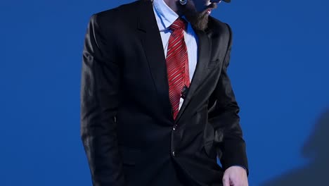 stylish man in suit and fedora against blue background