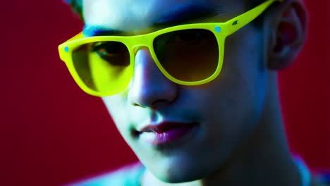 close-up of a man wearing neon yellow sunglasses