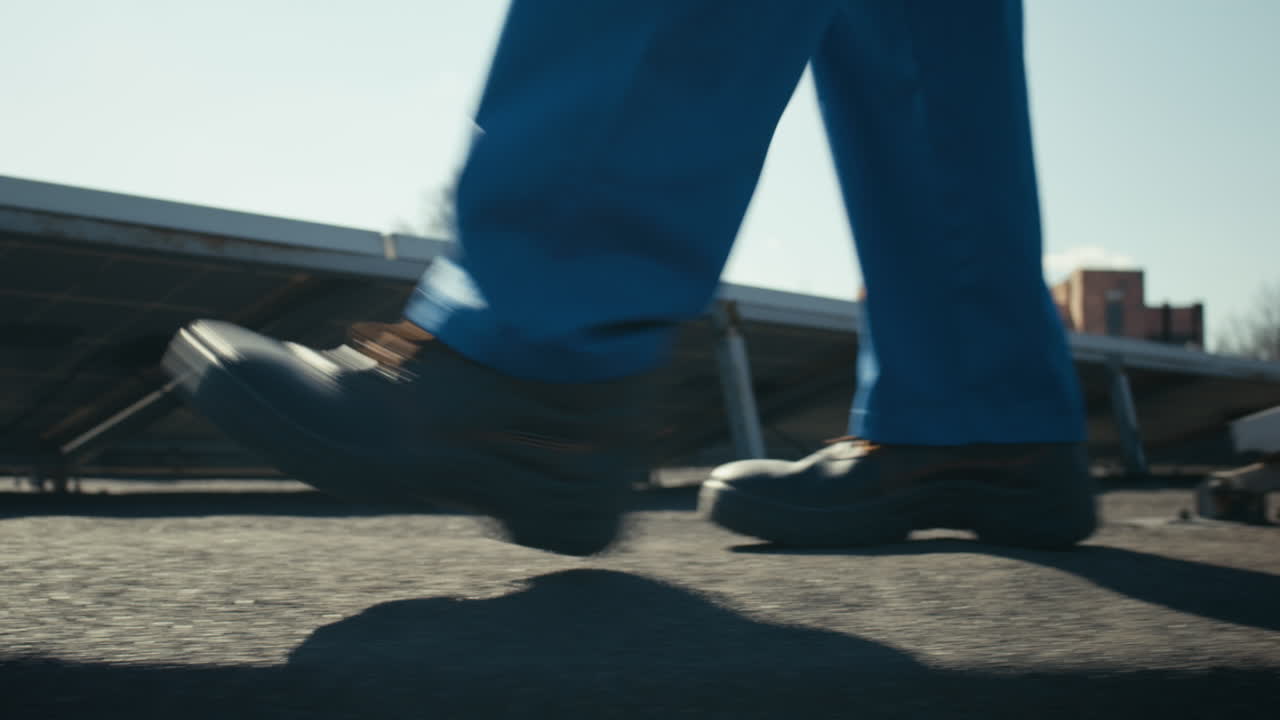 Worker walking on a rooftop with solar panels