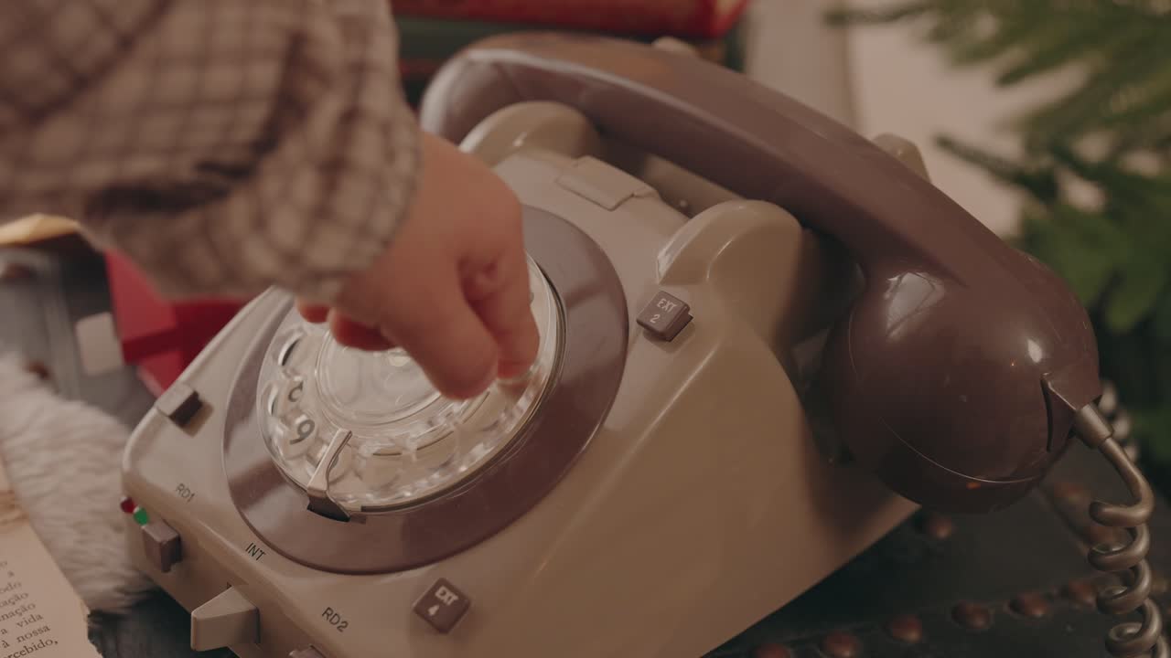Close up of kid's finger rotating dial on old retro phone in nostalgic home