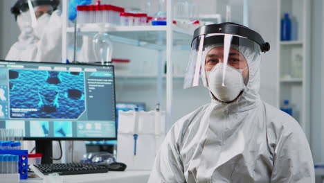 médico en traje de protección mirando agotado a la cámara