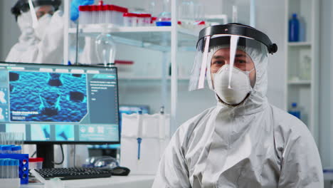 doctor in protection suit looking exhausted at camera