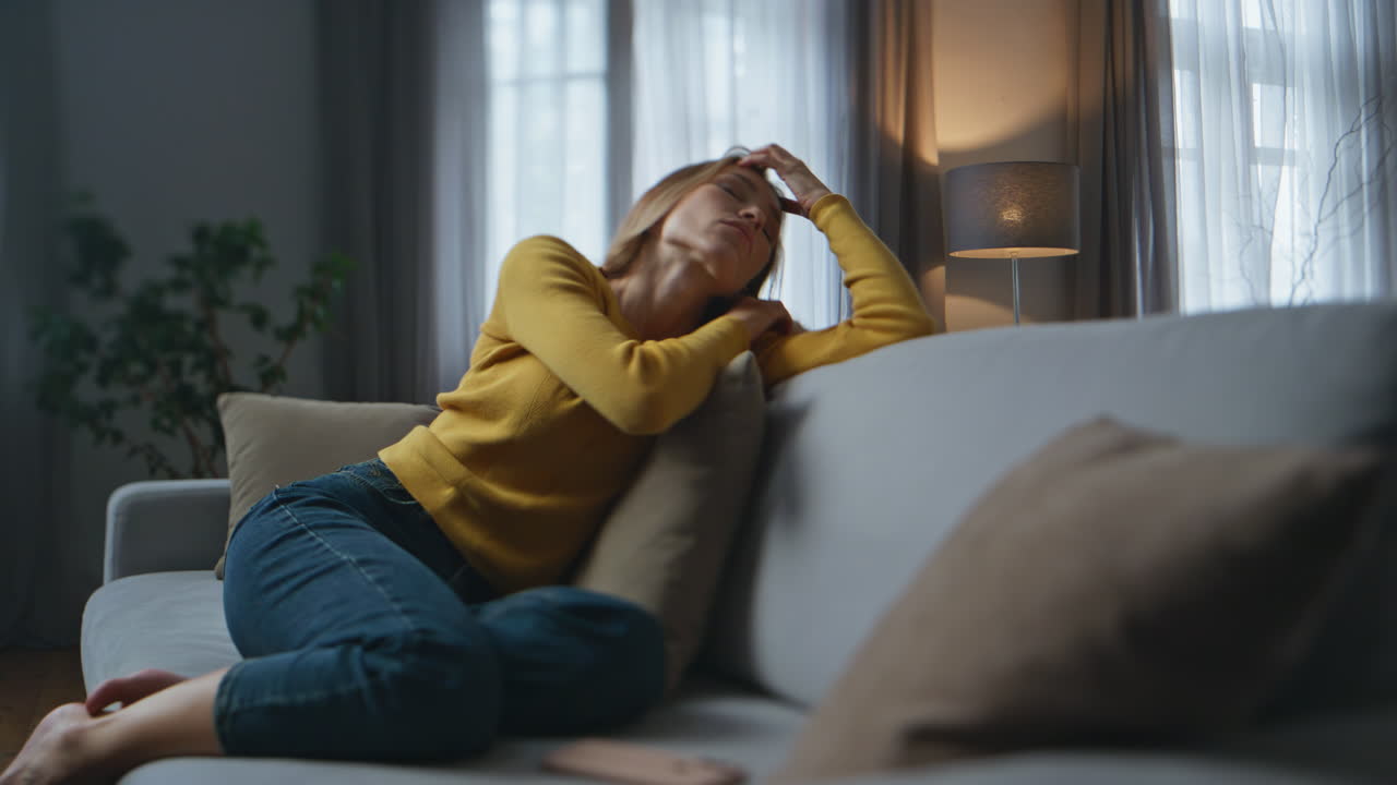 Heartbroken girl messaging smartphone dark house. Depressed lady sitting couch