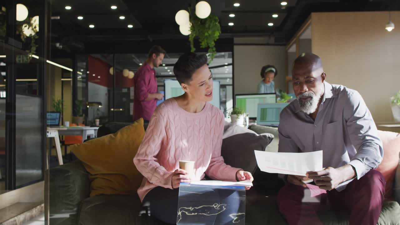 diversas personas de negocios sentadas con documentos y discutiendo el trabajo en la oficina