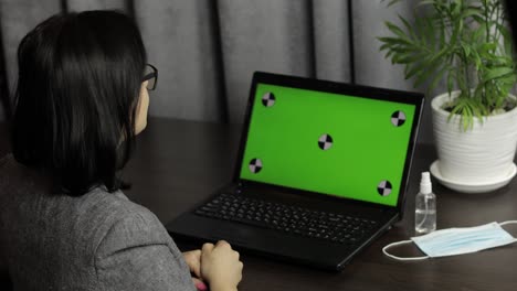 Woman-have-video-call-conference-on-laptop-with-green-screen.-Distance-work