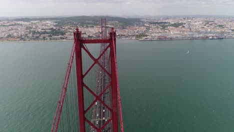 Aerial-view-to-Bridge-Ponte-25-de-Abril-over-the-Tagus-river-in-Lisbon,-Portugal-on-a-sunny-day-with-fluffy-clouds