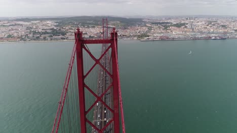 aerial view to bridge ponte 25 de abril over the tagus river in lisbon, portugal on a sunny day with fluffy clouds