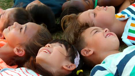 Close-up-of-schoolkids-lying-on-grass