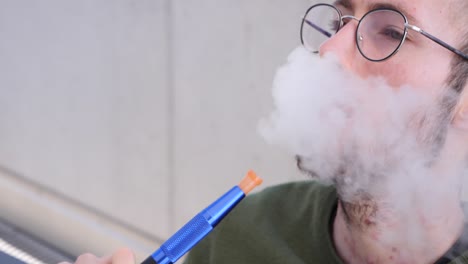 hombre caucásico enfermo con espinillas y enfermedades de la piel fumando cachimba peligrosa