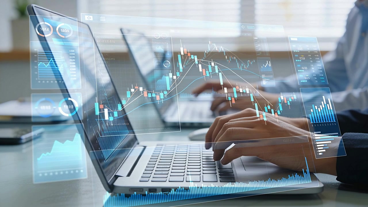 Mani che digitano e fanno trading alla scrivania con laptop, mentre i dati di mercato in tempo reale si aggiornano per l'analisi, in camicia.
