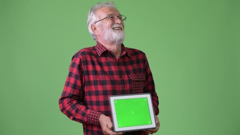 hombre de barba viejo y guapo contra un fondo verde.
