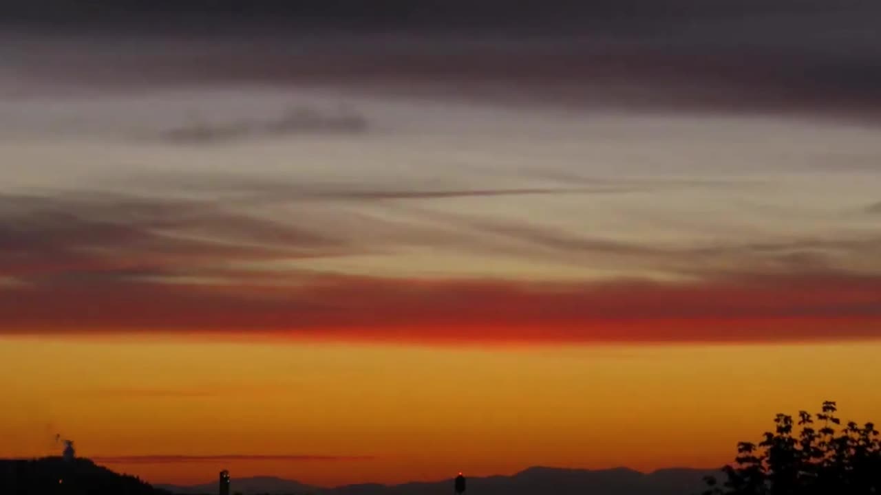 해가 지는 동안 오렌지색 구름이 움직입니다.