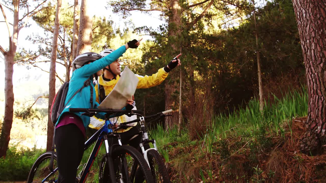 Mountain biking couple looking at map
