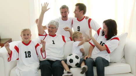 Familia-Extensa-Con-Abuelos-En-El-Sofá-Viendo-Fútbol