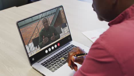 african american man using laptop for video call, with business colleague on screen