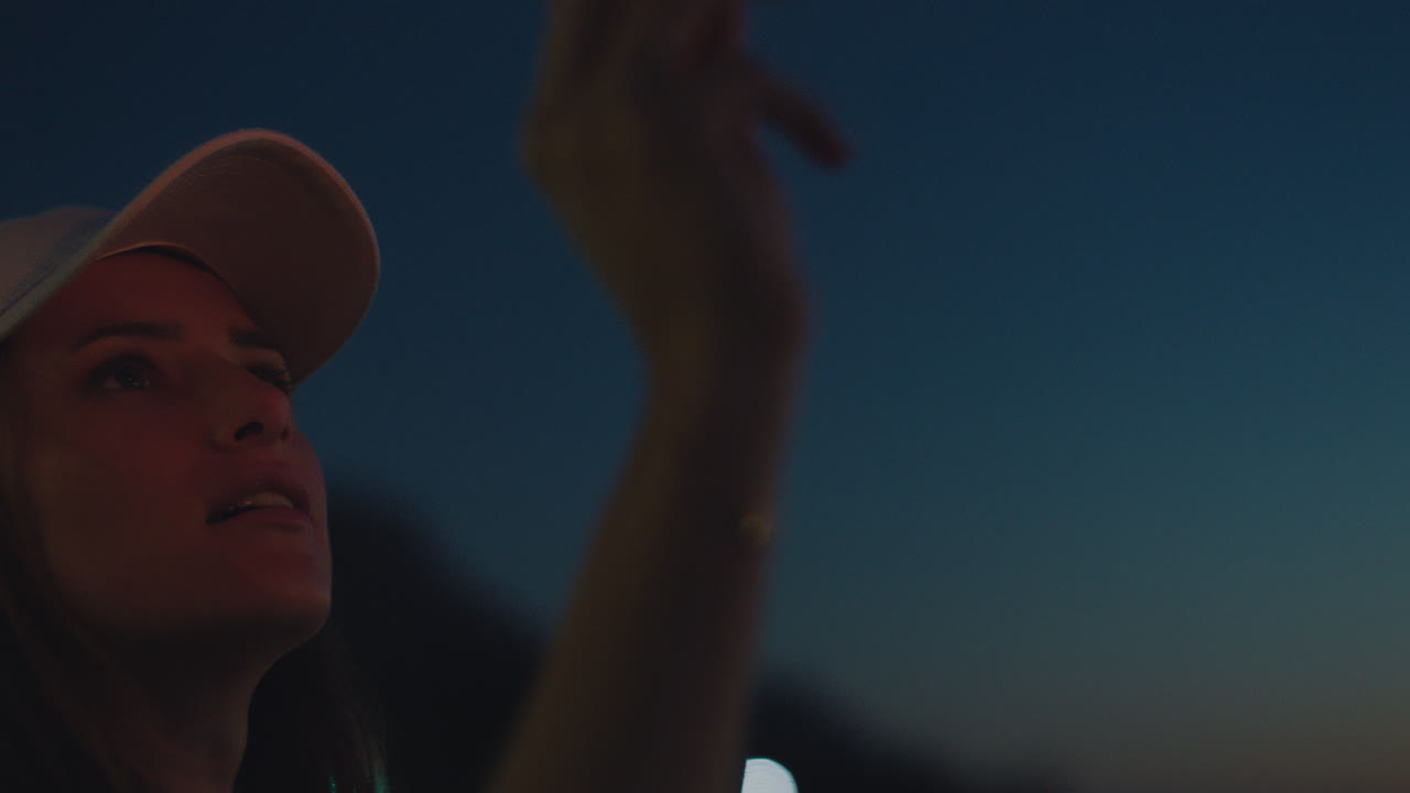 日没時にビーチで線香花火を持っている女性は、大晦日のお祝いを楽しんでいます。ふざけて線香花火を振って花火をしている女の子 7 月 4 日の独立記念日を祝っています。