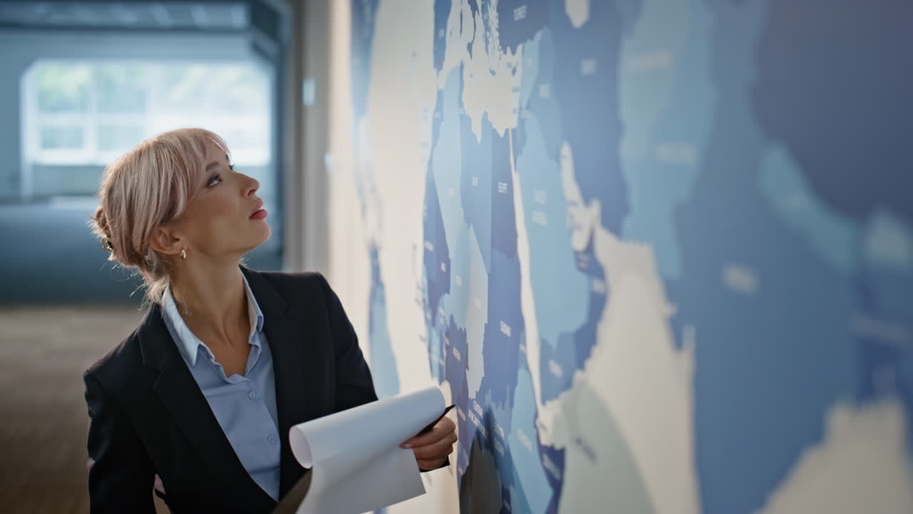 Sales manager analyzing map closeup. Satisfied businesswoman flipping documents