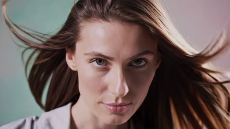 close-up portrait of a woman with long hair blowing in the wind