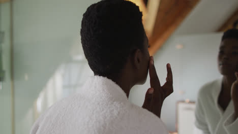 African-american-attractive-woman-taking-care-of-face-in-bathroom