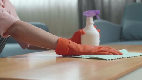 woman cleaning a wooden table