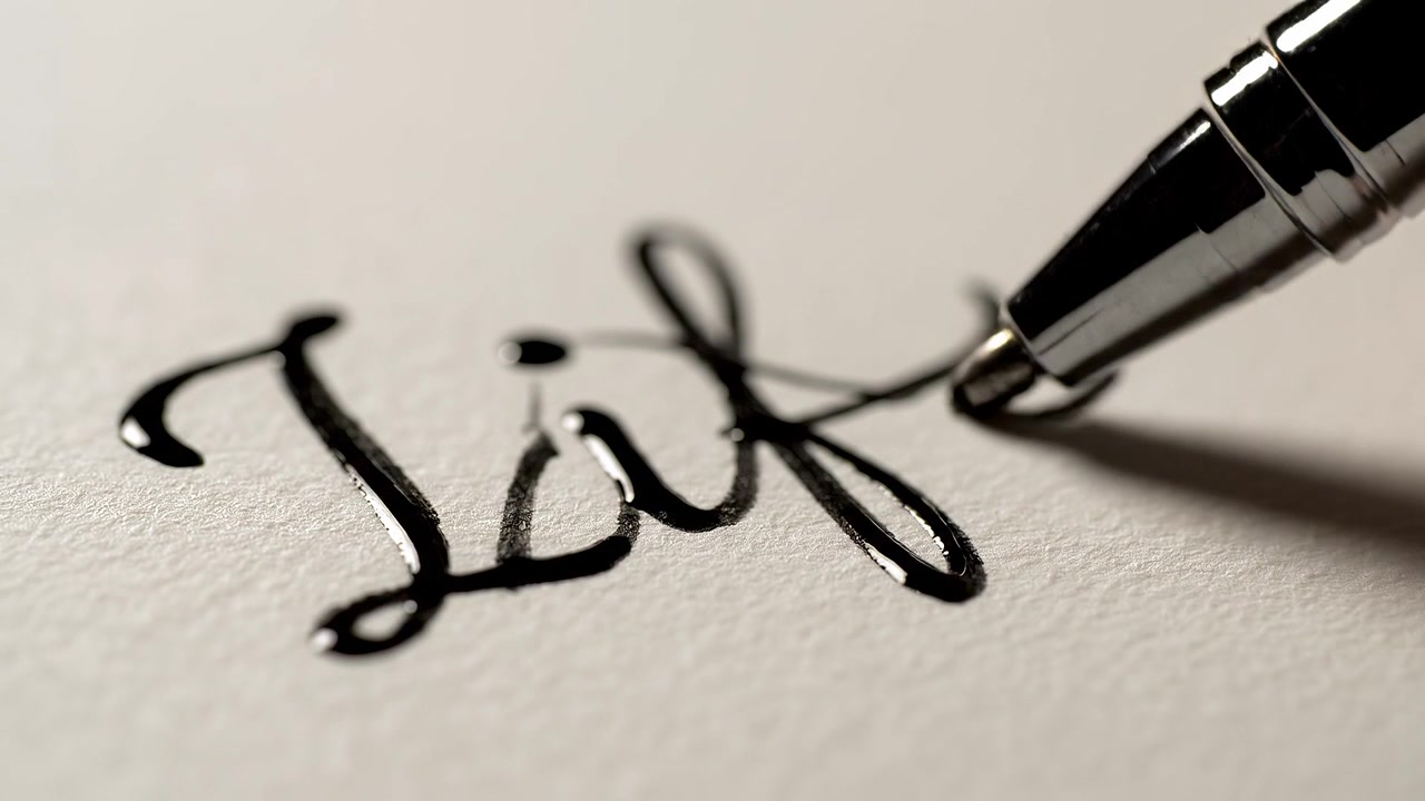 Close-up of a chrome pen writing on textured white paper