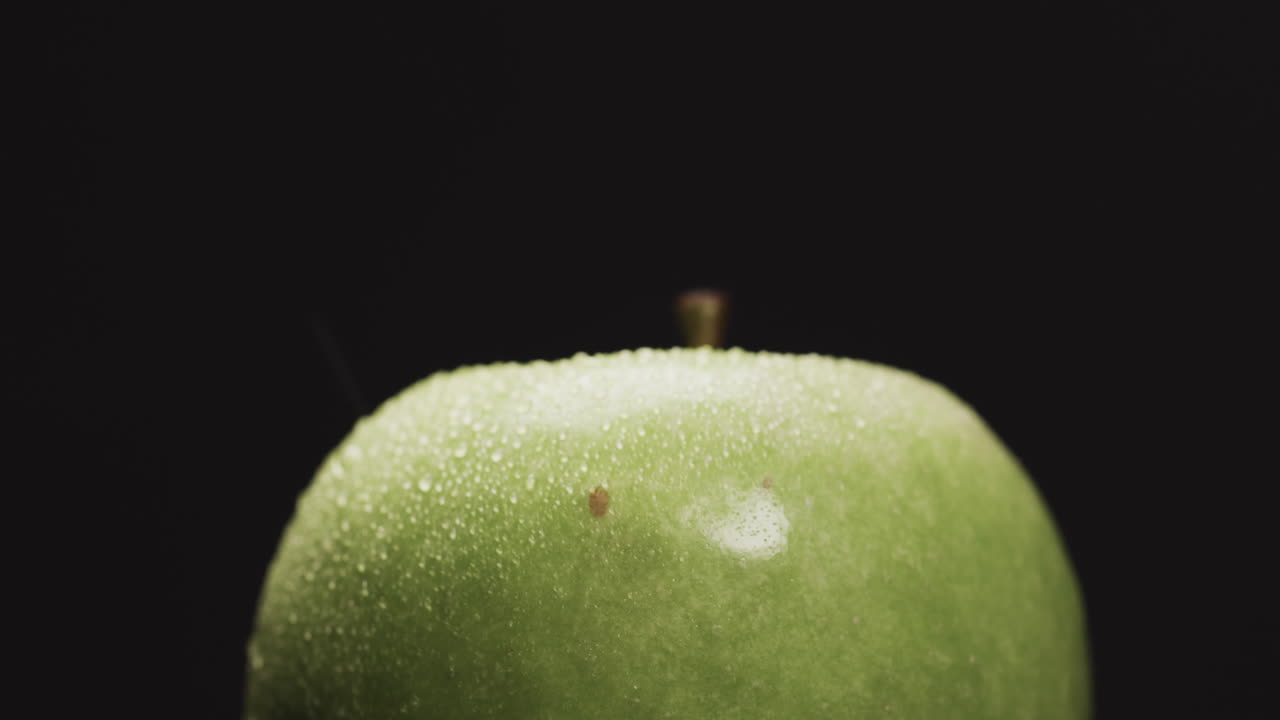 micro vídeo de primer plano de la manzana verde con espacio de copia en fondo negro