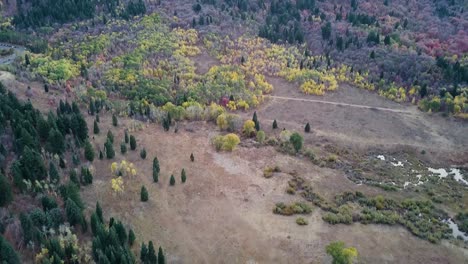 snow-basin-utah-vista-over-mountains-and-aspen-trees-paning-to-a-commercial-parking-lot-during-blue-hour---AERIAL-DOLLT-TILT