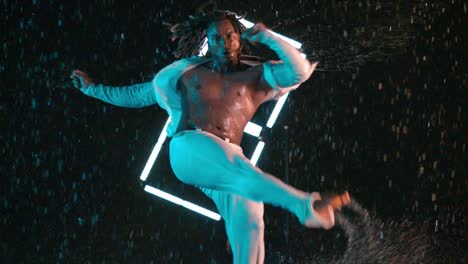 african-american performing capoeira dance kick in rain in super slow motion