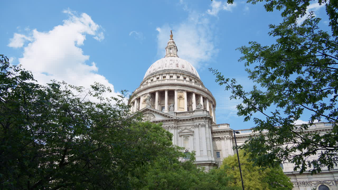 The Dome of St. Paul's Cathedral rising above the trees with a clear blue sky in the background in London, England