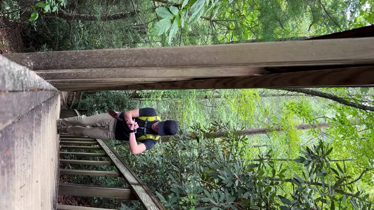 켄터키 주 캠든의 레드 리버 협곡에서 나무 계단을 걸어가는 젊은 백인 남성