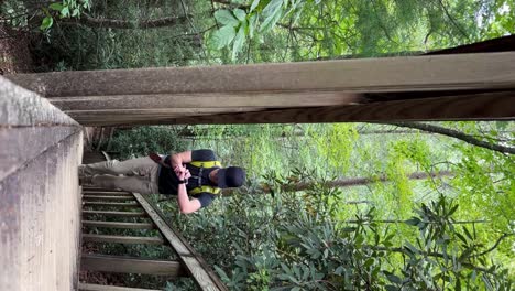 joven varón blanco subiendo una escalera de madera en el desfiladero del río rojo en camden, kentucky vertical