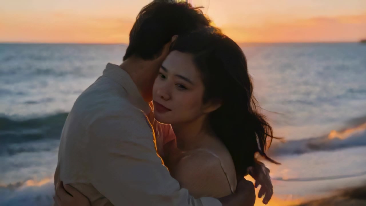 夕日が沈む砂浜で、明るいシャツとノースリーブのドレスを着たロマンチックなカップルが寄り添い抱き合っている。
