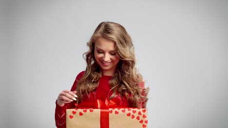 Mujer-Emocionada-Abriendo-Un-Regalo-En-Una-Foto-De-Estudio.