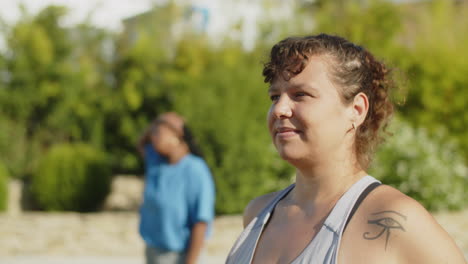 static shot of body positive woman stretching arms in park