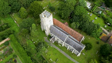 Ein-Bogenschuss-über-Der-Holy-Cross-Kirche-In-Goodnestone,-Der-Die-Kirche-Und-Den-Friedhof-Umkreist