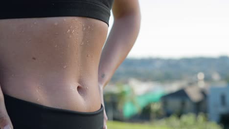 female stomach with sweat dripping down abs