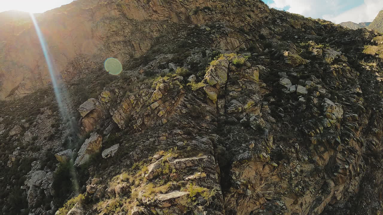 antiguas montañas rocosas a la luz del sol brillante vista aérea. majestuoso paisaje con cresta empinada como testimonio del poder crudo de la naturaleza. los rayos del sol bailan sobre los acantilados