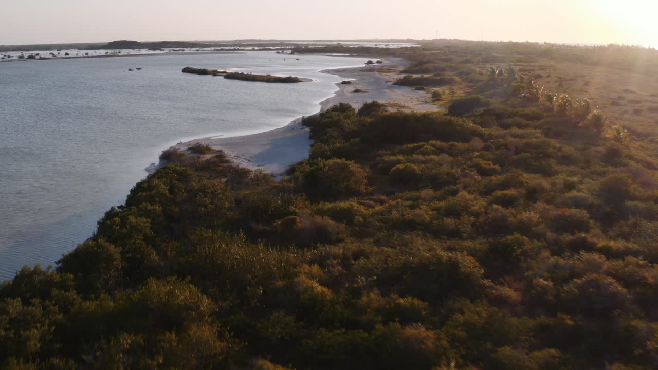 Veicolo overland solitario parcheggiato vicino alla costa con il riflesso dorato della luce del tramonto sull'acqua