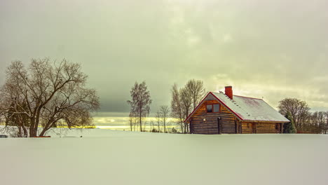 A-hut-nestled-in-a-forest-is-surrounded-by-winter-snowfall,-creating-a-stunning-snowy-blanket-in-every-direction