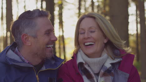 head and shoulders shot of laughing mature couple on walk through fall or winter countryside - shot in slow motion