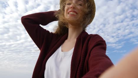 low angle view of young beautiful caucasian woman in hat smiling an looking at camera 4k